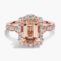 an engagement ring with a large peach morganite surrounded by small white diamonds in rose gold