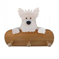 a white dog sitting on top of a wooden board