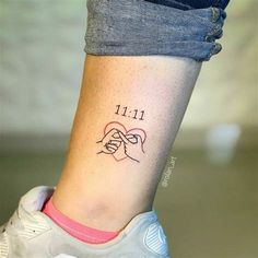 a woman's foot with a small tattoo on her left ankle and the words 11 11