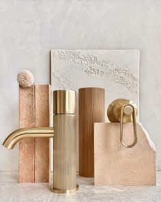 gold bathroom accessories and soap dispenser on white marble countertop with textured background