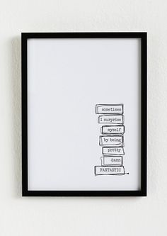 a black frame hanging on the wall next to a white wall with a stack of books