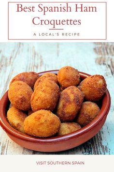 a bowl filled with fried food on top of a wooden table