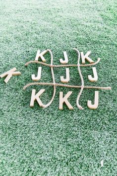 the letters are made out of wood and rope on the ground with green grass in the background