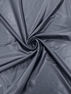 an up close shot of a grey fabric with very thin lines and folds in the center