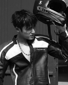 a young man wearing a leather jacket and helmet