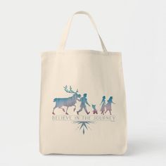 a tote bag with the words believe in the journey and two people walking behind it