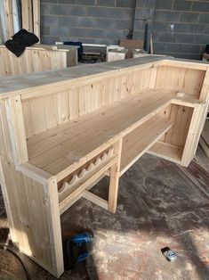 a wooden bench sitting inside of a room next to a brick wall on the floor