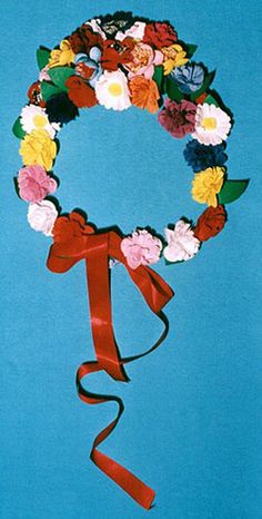 a flower wreath with red ribbon on a blue background