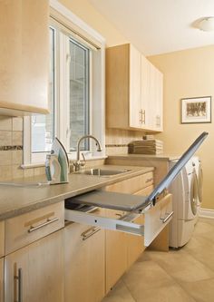 a kitchen with wooden cabinets and stainless steel sink, dishwasher and dryer