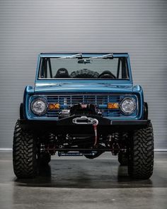 the front end of a blue truck parked in a garage