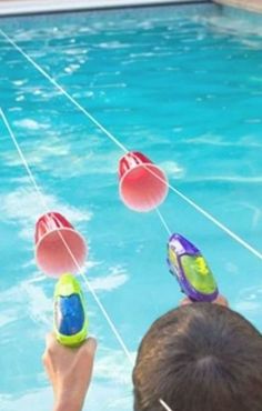 two people are floating in the water with floats attached to their heads, and one person is wearing flippers