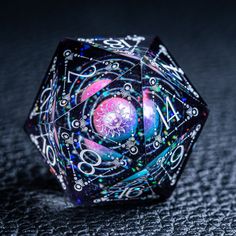 a close up of a dice on a black surface with colorful lights and numbers around it