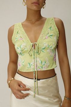 Add a pop of color to your summer wardrobe with the Dreamer Top Green. Featuring a delicate pink floral pattern and tie detail in the center, this top is perfect for a date night or night out. Pair it with the matching Dreamer Mini Skirt Green for a... Feminine V-neck Tie Back Tops, Spring V-neck Blouse With Tie Back, Spring Sleeveless Top With Tie Waist, Chic Tie Waist Tops For Vacation, Chic Tops With Tie Waist For Vacation, Sleeveless Tie Waist Top For Spring, Sleeveless Tops With Tie Waist For Spring, Fitted Sleeveless Top With Tie Waist, Fitted Sleeveless Tie Waist Tops