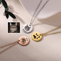 three different necklaces with cats on them and one has a cat's face