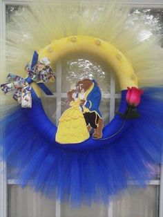 a blue and yellow wreath decorated with beauty and the beast