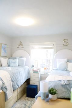 two beds in a bedroom with blue and white bedding