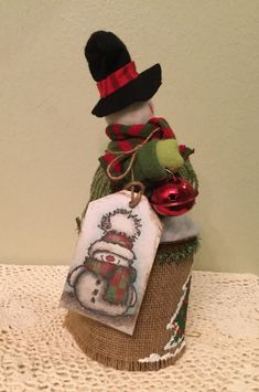 a snowman sitting on top of a cupcake with a tag attached to it