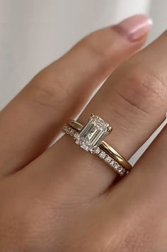 a woman's hand with a diamond ring on top of her finger and an engagement band