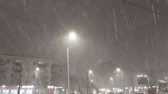 a snowy night in the city with street lights