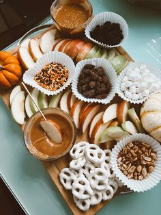 an assortment of snacks on a tray with dipping sauces and pretzel rings