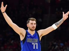 a basketball player with his arms in the air and one hand raised up while standing on a court