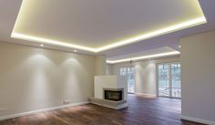 an empty living room with hard wood floors and white lighting on the ceiling is lit by recessed lights