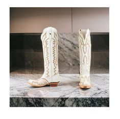 Dan Post Women's Josie Tall Western Boots (Snip Toe) Medium Sizes in a crisp and classic white color. These boots feature a sleek 17.5" shaft height and a comfortable 1.5" western heel, making them a versatile option for any occasion. Crafted from high-quality leather, these boots boast a snip toe and rose scallops for a feminine and elegant touch. The single-stitched welt construction ensures durability, while the leather outsole with a rubber heel cap provides stability and traction. The zippe Fitted White Snip Toe Boots, Fitted White Boots With Flat Heel, White Fitted Boots With Flat Heel, Classic White Fitted Boots, Classic White Snip Toe Boots, White Snip Toe Boots For Spring, Classic White Pointed Toe Boots, White Closed Toe Boots Medium Width, White Medium Width Closed Toe Boots