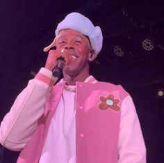 a man in a pink jacket singing into a microphone