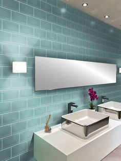 a bathroom with two sinks and a mirror on the wall next to each other in front of a blue tiled wall