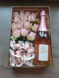 a bottle of wine and roses in a box