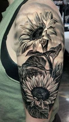 a woman's arm with sunflowers and leaves tattoo on the left shoulder