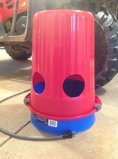 a red and blue device sitting on top of a floor next to a tire track