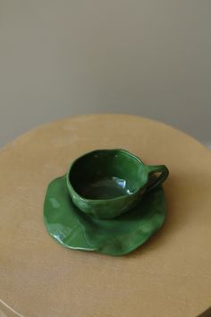 a green saucer sitting on top of a wooden table