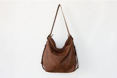 "Convertible leather bag: Converts from backpack to shoulder bag and crossbody bag with the single use of one strap. The main style of the bag is a soft and slouchy hobo bag. The permanent long strap on the bag can be easily adjusted to your desired length in order to wear the bag on your shoulder, as a crossbody bag or as a backpack. **Important point is that when you adjust the strap to a backpack the strap is stable and does not slide from one side to the other. Made from soft Italian distres Everyday Shoulder Bag With Detachable Strap, Hobo Shape, Everyday Hobo Shoulder Bag With Detachable Strap, Leather Hobo Bag Backpack With Large Capacity, Versatile Soft Leather Hobo Satchel Bag, Versatile Hobo Satchel For Errands, Versatile Hobo Satchel, Versatile Soft Leather Backpack Satchel, Versatile Shoulder Bag With Leather Handles In Backpack Style, Versatile Hobo Satchel With Leather Handles