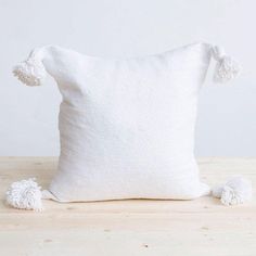 a white pillow with pom - poms on it