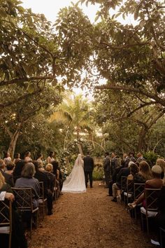 a bride and groom walking down the aisle at their wedding ceremony in an outdoor setting