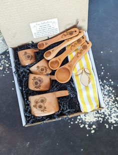 six wooden spoons in a box on a table