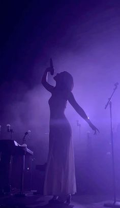 a woman standing in front of microphones on stage