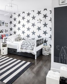 a black and white bedroom with stars on the wall