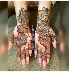 two hands with henna tattoos on them