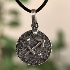 a silver pendant with the letter y on it's side and a black cord