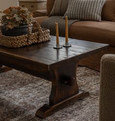 a wooden table with candles on it in front of a couch