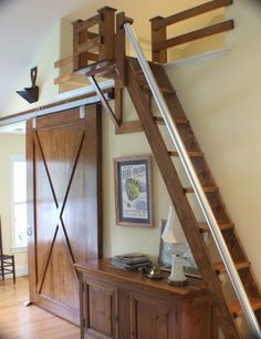 a living room with wooden furniture and a ladder to the top of the wall above it