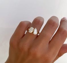 a woman's hand with a three stone ring on top of her left hand