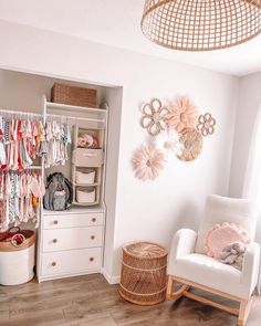 a baby's room with white furniture and pink accessories on the wall, including a rocking chair