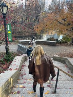 a woman walking up some steps in the fall