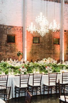 the tables are set with white linens and greenery for an elegant wedding reception