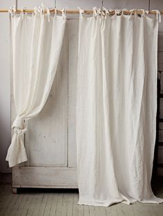 a white curtain hanging on the side of a wooden door