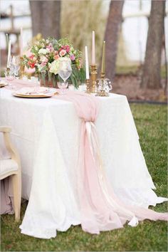 the table is set with candles, plates and napkins for an elegant wedding reception