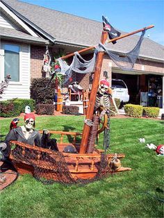 a pirate ship made out of wood sitting in the grass next to a house with lots of decorations on it